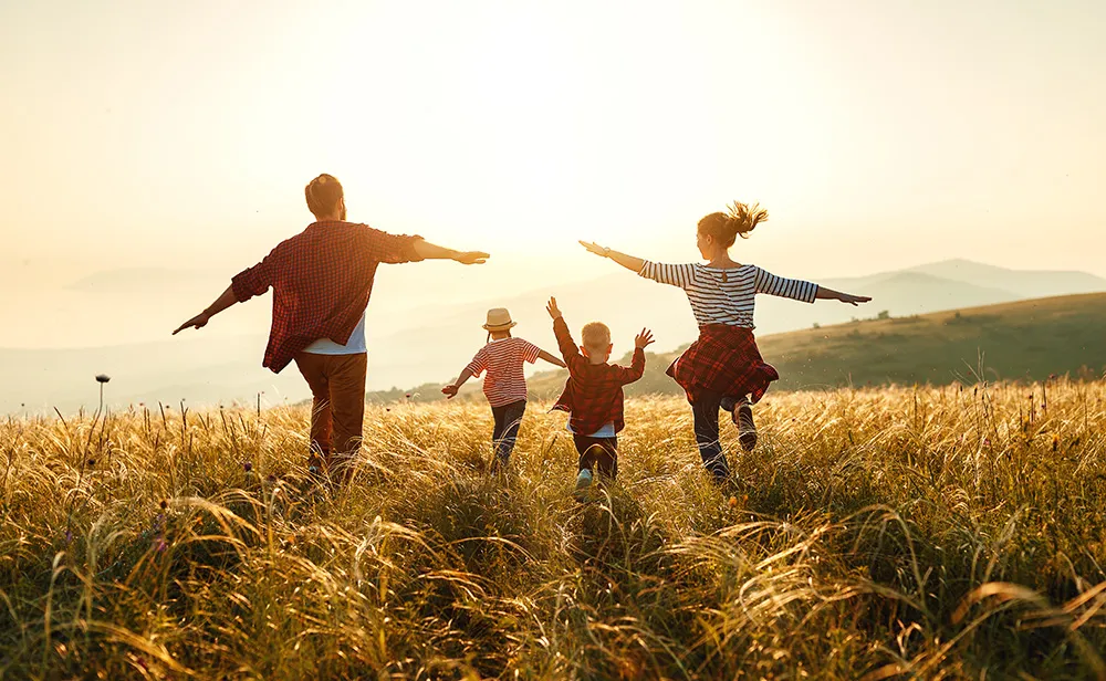 Eine Familie rennt auf einen Sonnenuntergang zu